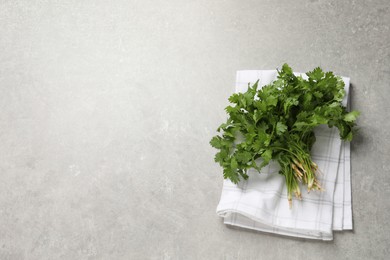 Photo of Bunch of fresh aromatic cilantro on grey table, top view. Space for text