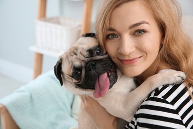 Woman with cute pug dog at home. Animal adoption