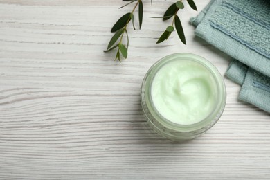 Photo of Jar of organic cream, towel and eucalyptus on white wooden table, flat lay. Space for text