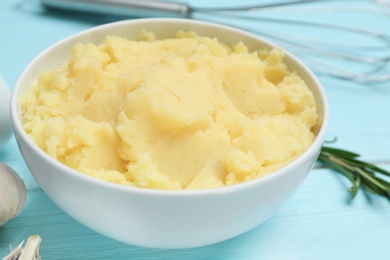 Photo of Bowl with mashed potatoes on wooden table