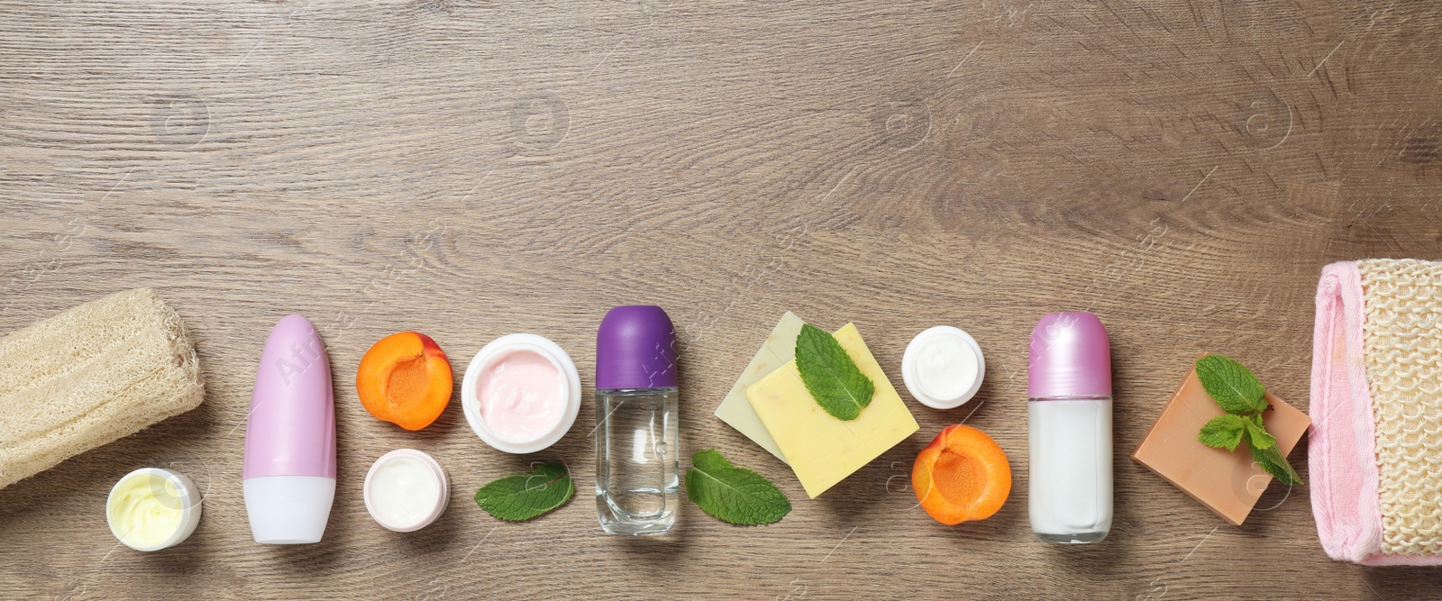 Photo of Flat lay composition with natural roll-on deodorants on wooden table. Space for text