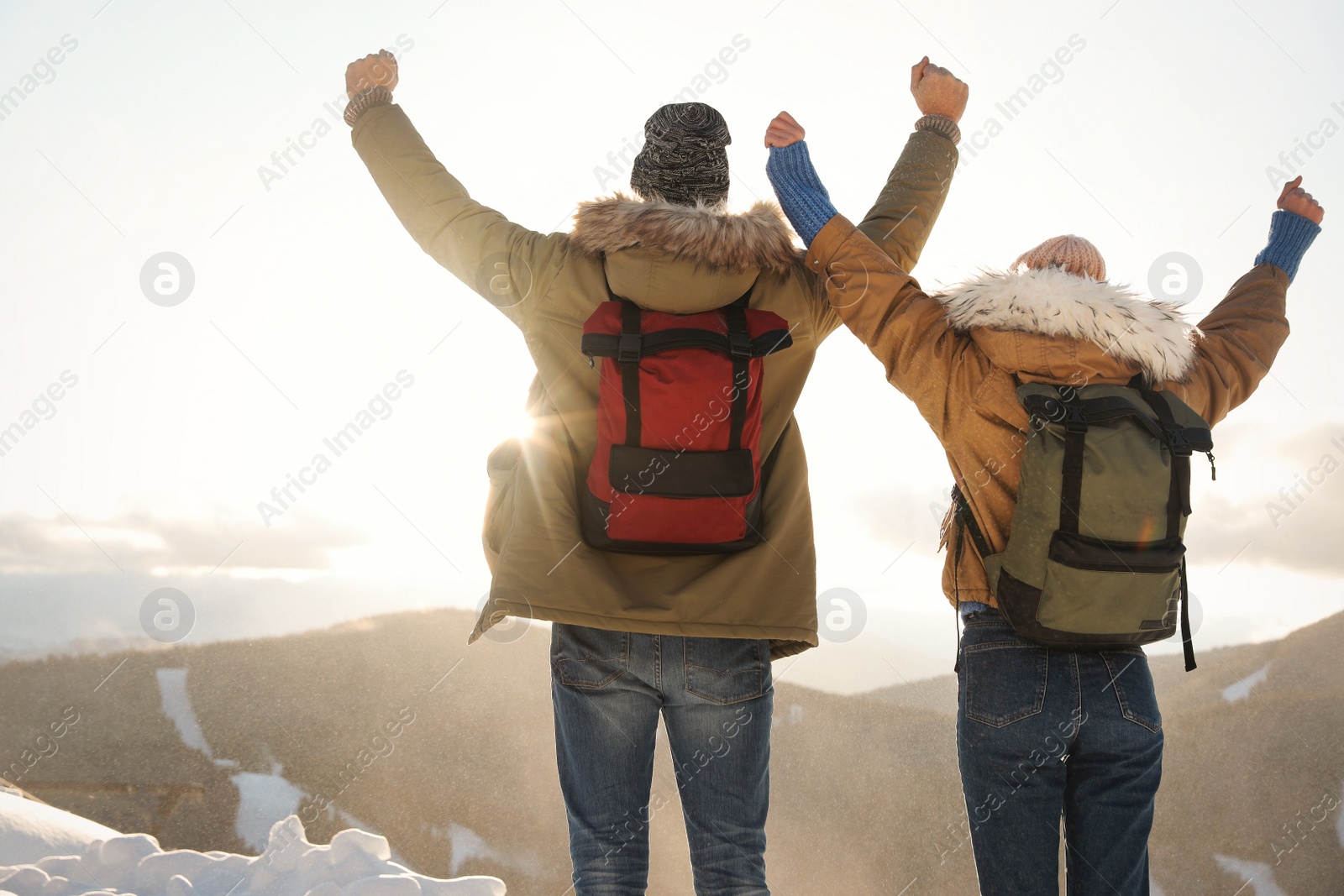 Photo of Excited couple with backpacks enjoying mountain view during winter vacation