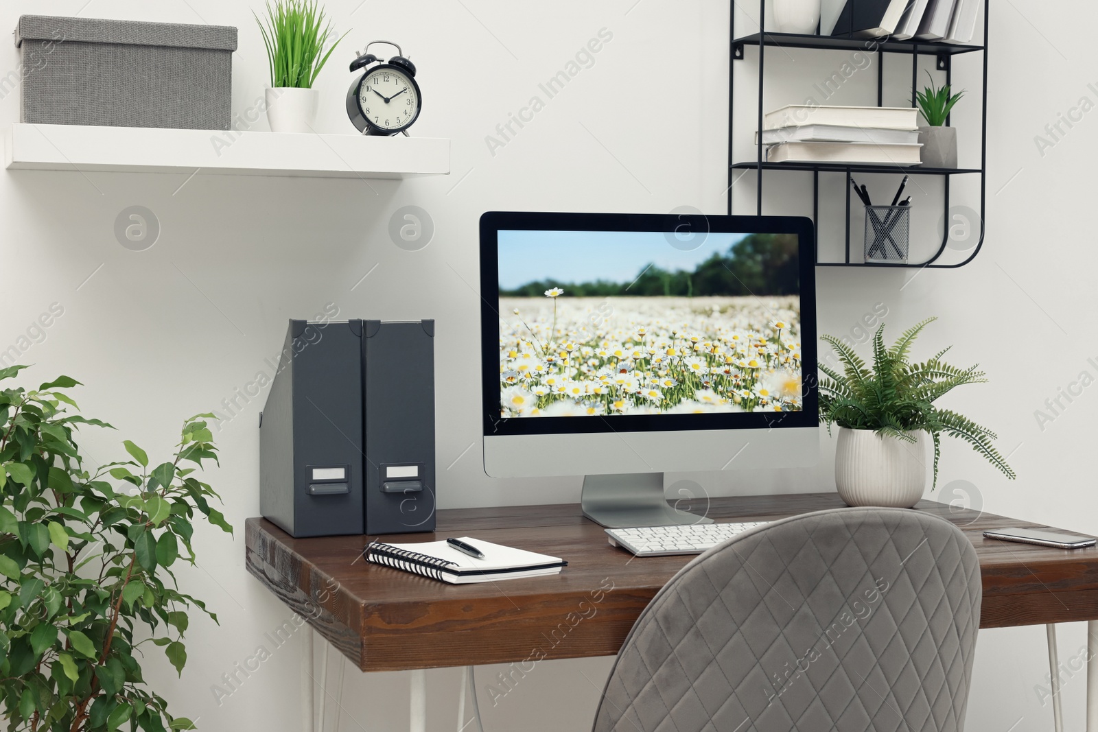 Photo of Cozy workspace with computer on wooden desk at home