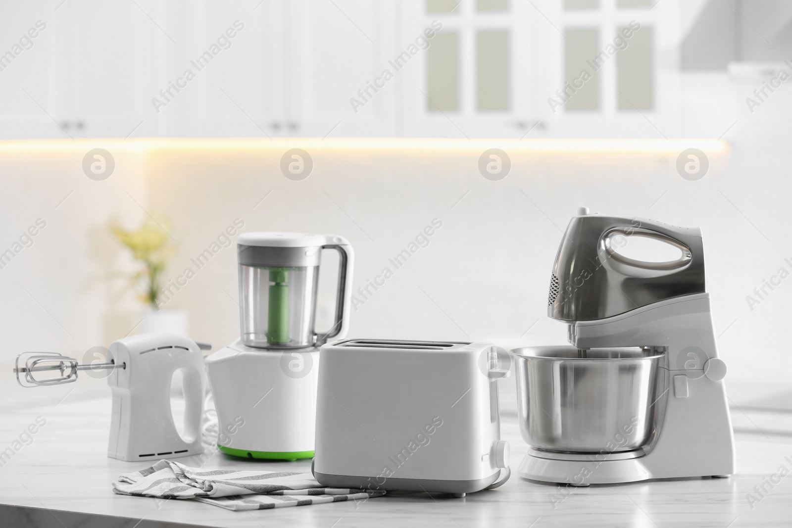 Photo of Modern toaster and other cooking appliances on table in kitchen