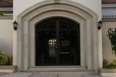 Photo of Entrance of house with beautiful arch and metal gate