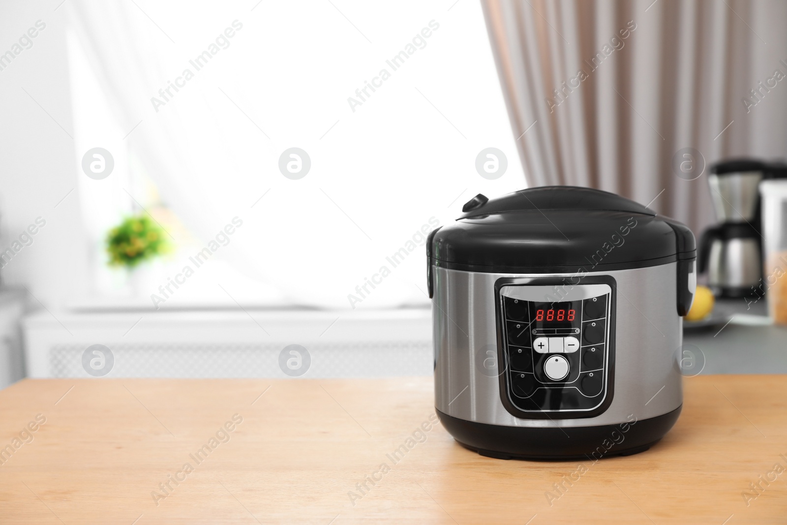 Photo of New modern multi cooker on table indoors. Space for text