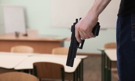 Image of School shooting. Man with gun in classroom, closeup