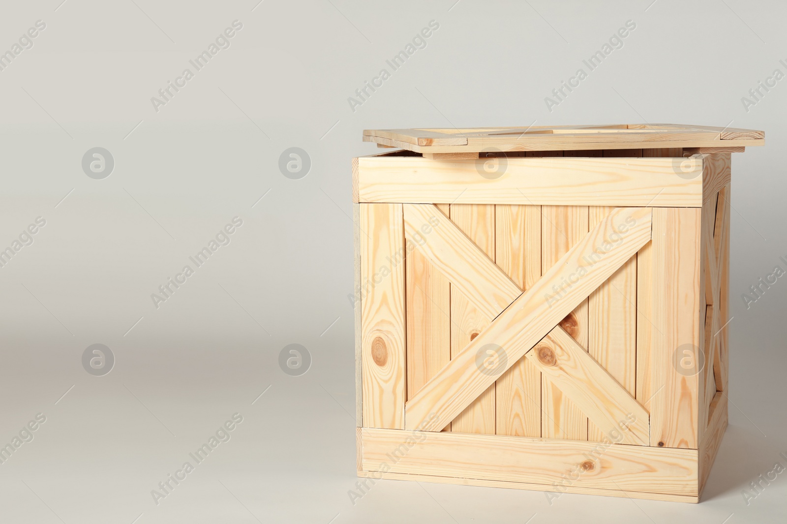 Photo of Wooden crate with lid on light background, space for text