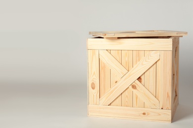 Photo of Wooden crate with lid on light background, space for text