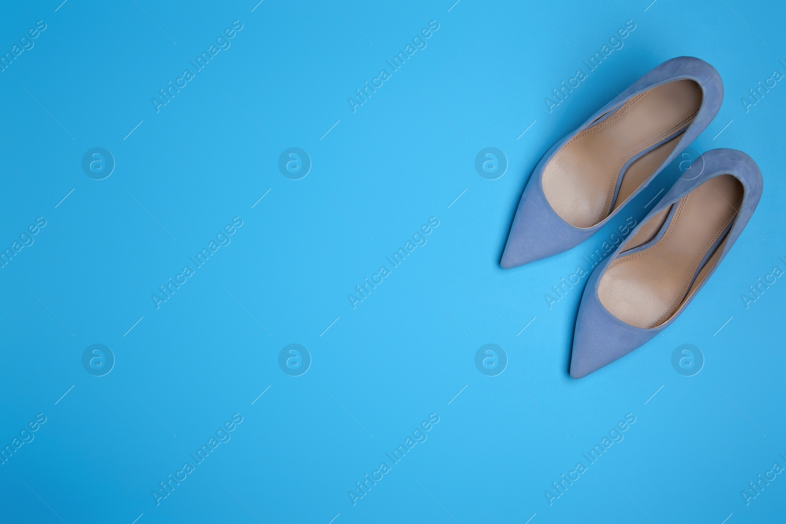 Photo of Pair of stylish women's shoes on blue background, flat lay. Space for text