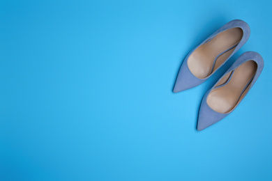 Pair of stylish women's shoes on blue background, flat lay. Space for text