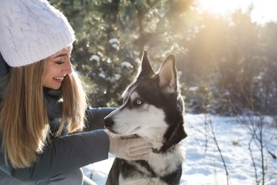 Photo of Young woman with dog in forest on winter day, space for text