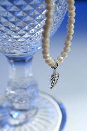 Photo of Stylish presentation of elegant pearl necklace on color background, closeup