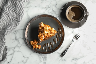 Piece of delicious homemade cake with caramel sauce and popcorn on table, top view