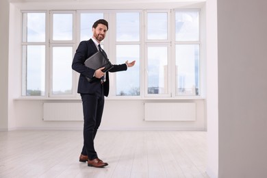 Happy real estate agent with leather portfolio showing new apartment