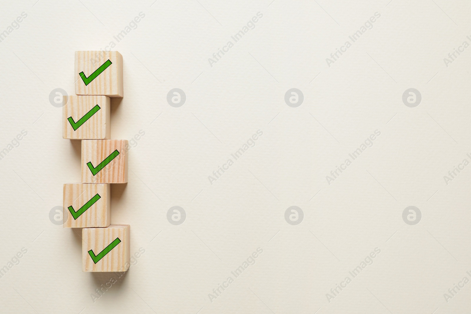 Image of Wooden cubes with check marks on beige background, flat lay. Space for text