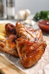 Photo of Delicious fried chicken wings served on table, closeup