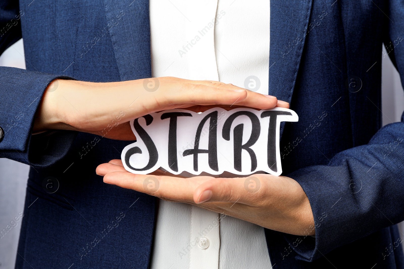 Photo of Woman holding sheet of paper with word Start, closeup