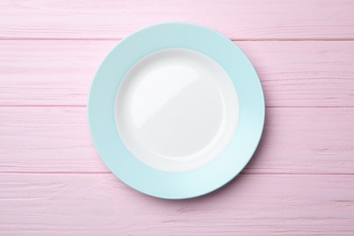 Photo of Stylish ceramic plate on wooden background, top view