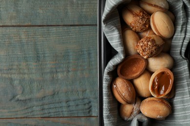 Freshly baked homemade walnut shaped cookies with condensed milk on wooden table, top view. Space for text