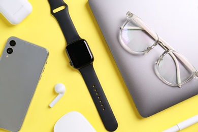 Photo of Flat lay composition with stylish smart watch on yellow background