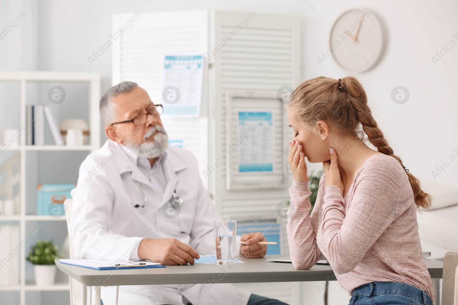 Photo of Coughing young woman visiting doctor at clinic