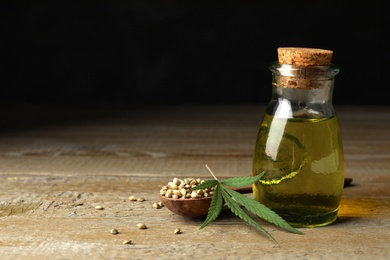 Composition with hemp oil on wooden table. Space for text