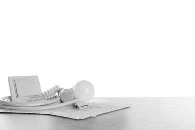 Set of electrician's tools and accessories on grey table against white background