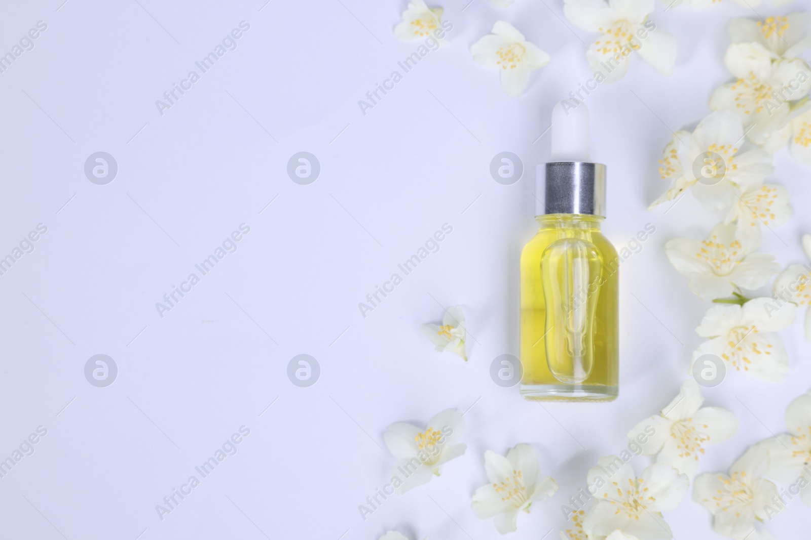 Photo of Essential oil in bottle and beautiful jasmine flowers on white background, flat lay. Space for text