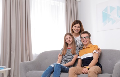 Happy mother with her teenager daughter and son at home