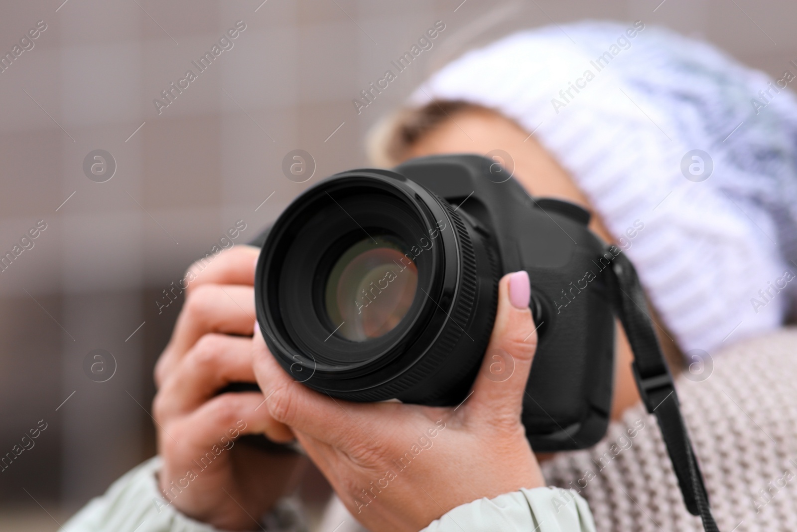 Photo of Photographer taking photo outdoors, focus on camera