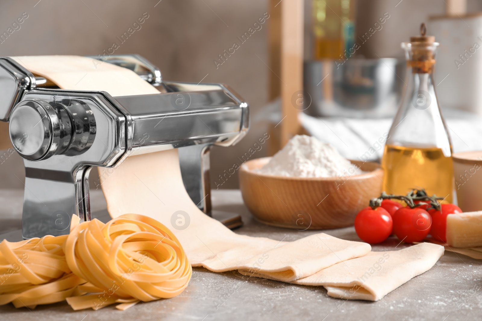 Photo of Pasta maker with dough and products on kitchen table
