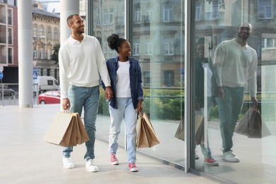 Photo of Family shopping. Happy couple with purchases near mall outdoors