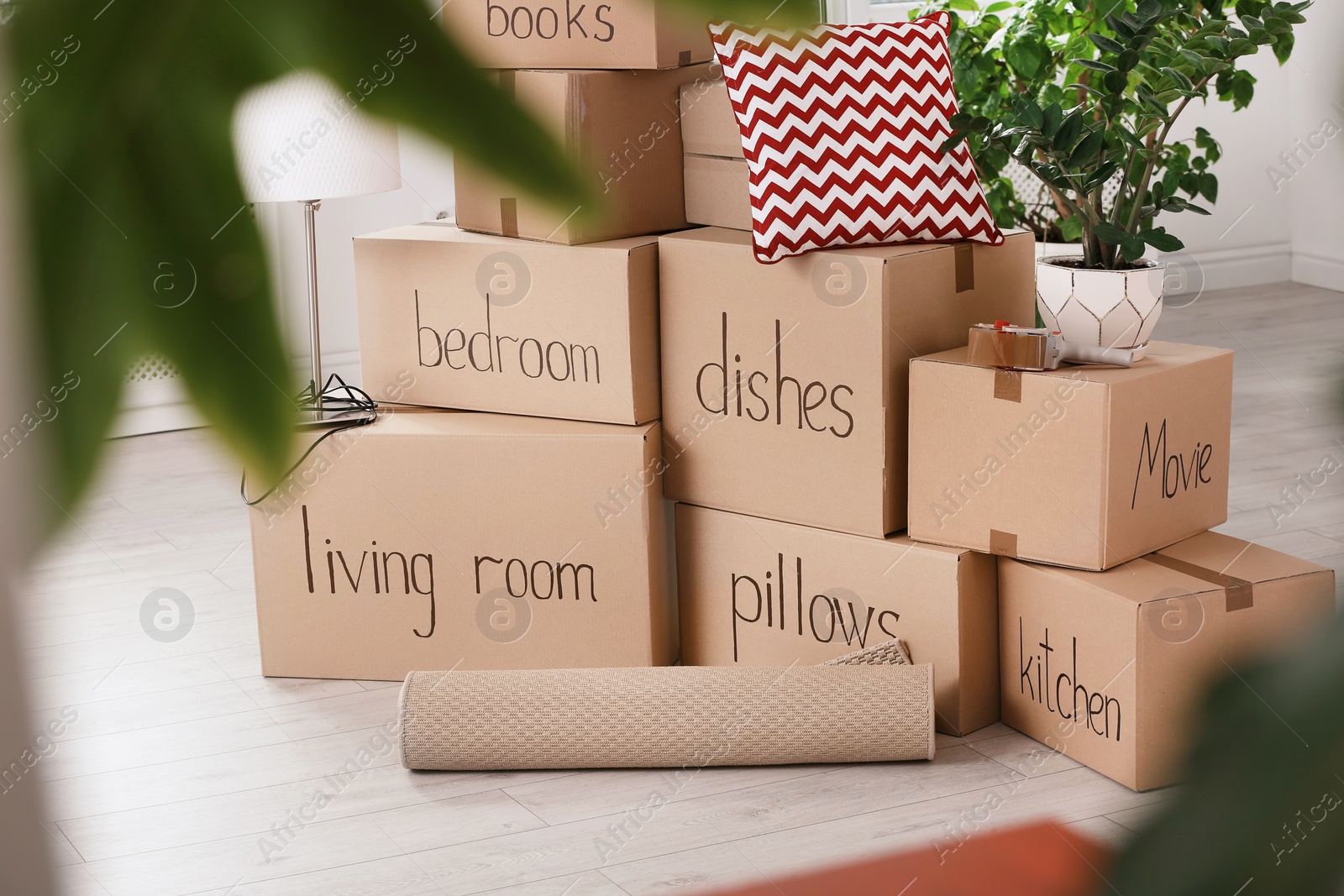 Photo of Pile of moving boxes and household stuff indoors