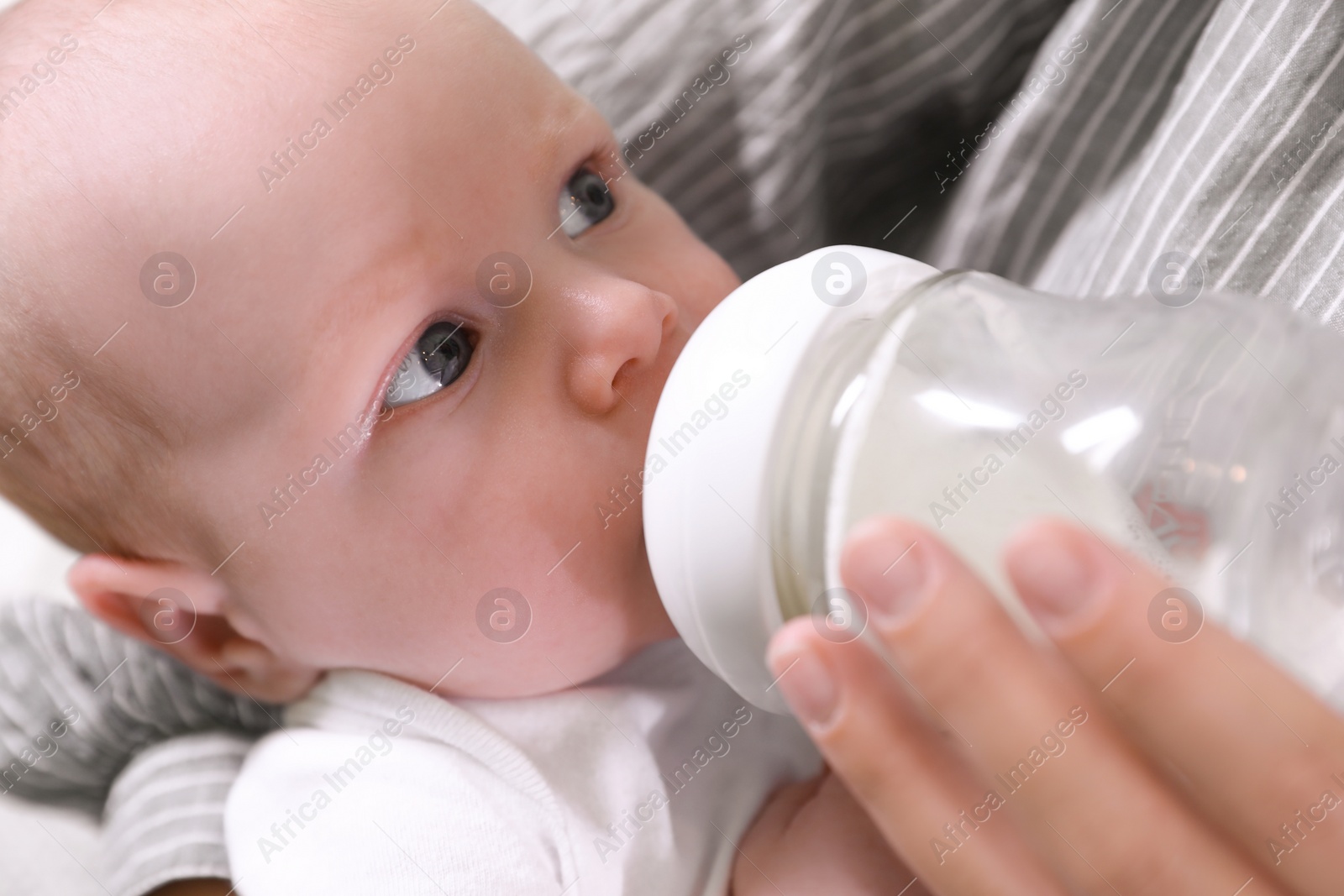 Photo of Mother feeding her little baby from bottle, closeup