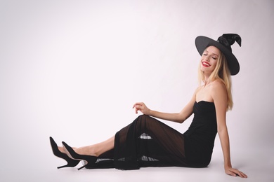 Photo of Beautiful woman in witch costume on white background, space for text. Halloween party
