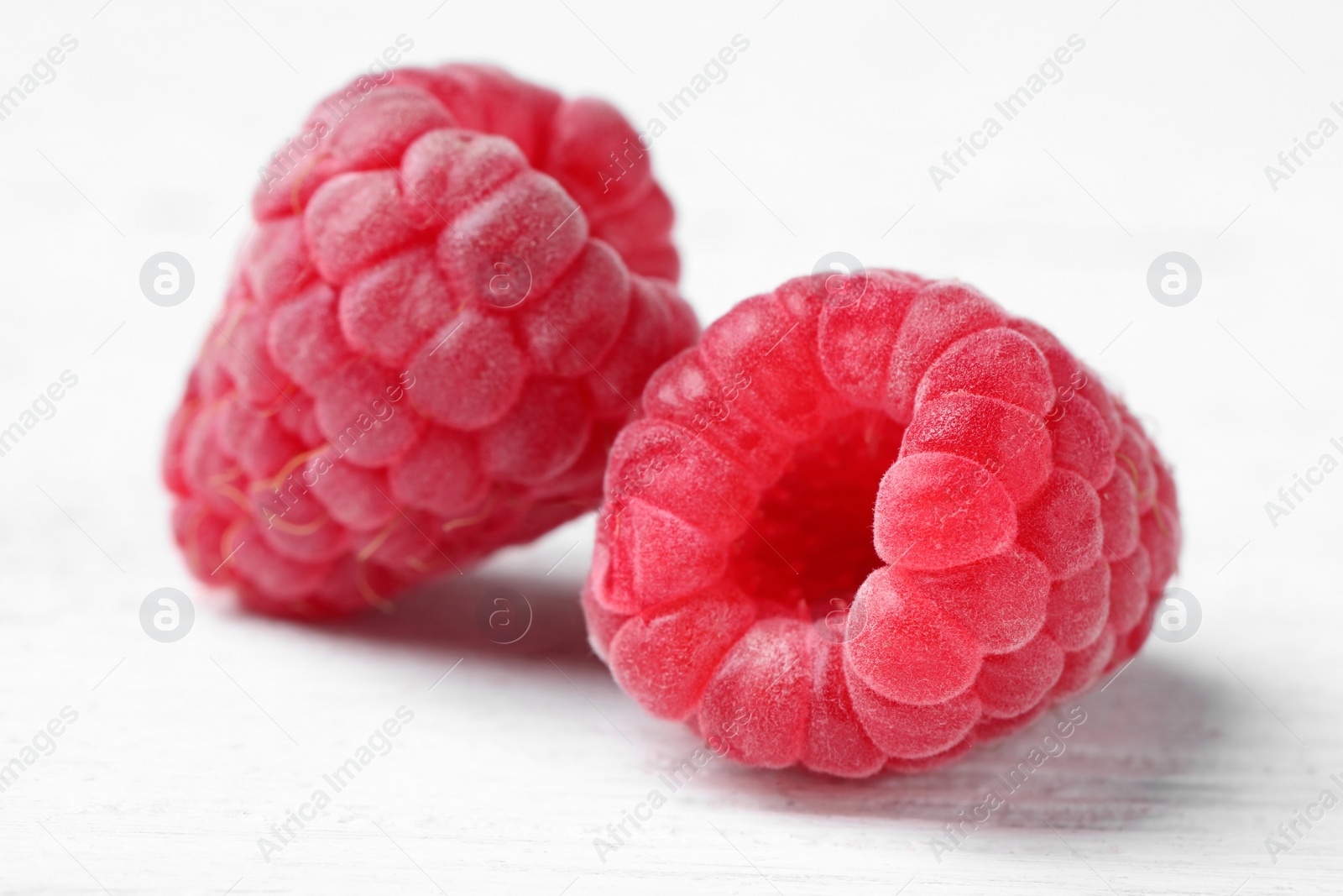 Photo of Delicious fresh ripe raspberries on white wooden table, closeup view