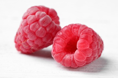 Delicious fresh ripe raspberries on white wooden table, closeup view