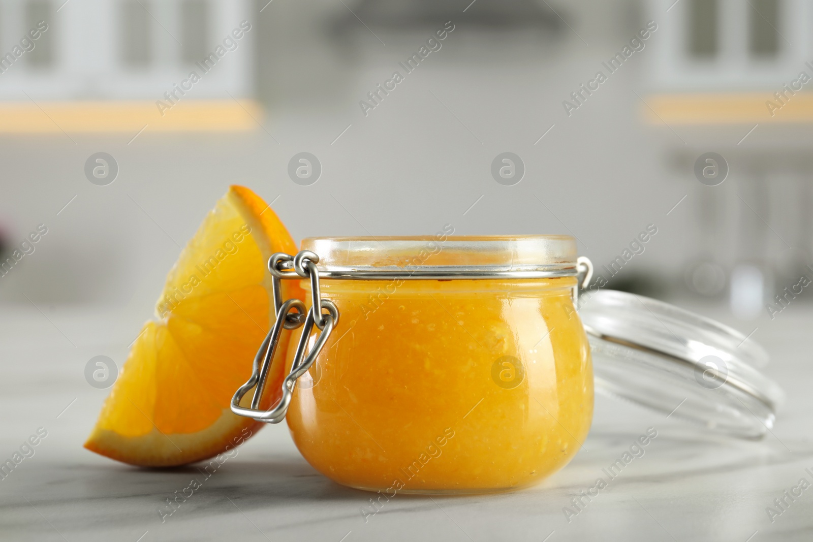 Photo of Delicious orange marmalade and citrus fruit slice on white marble table