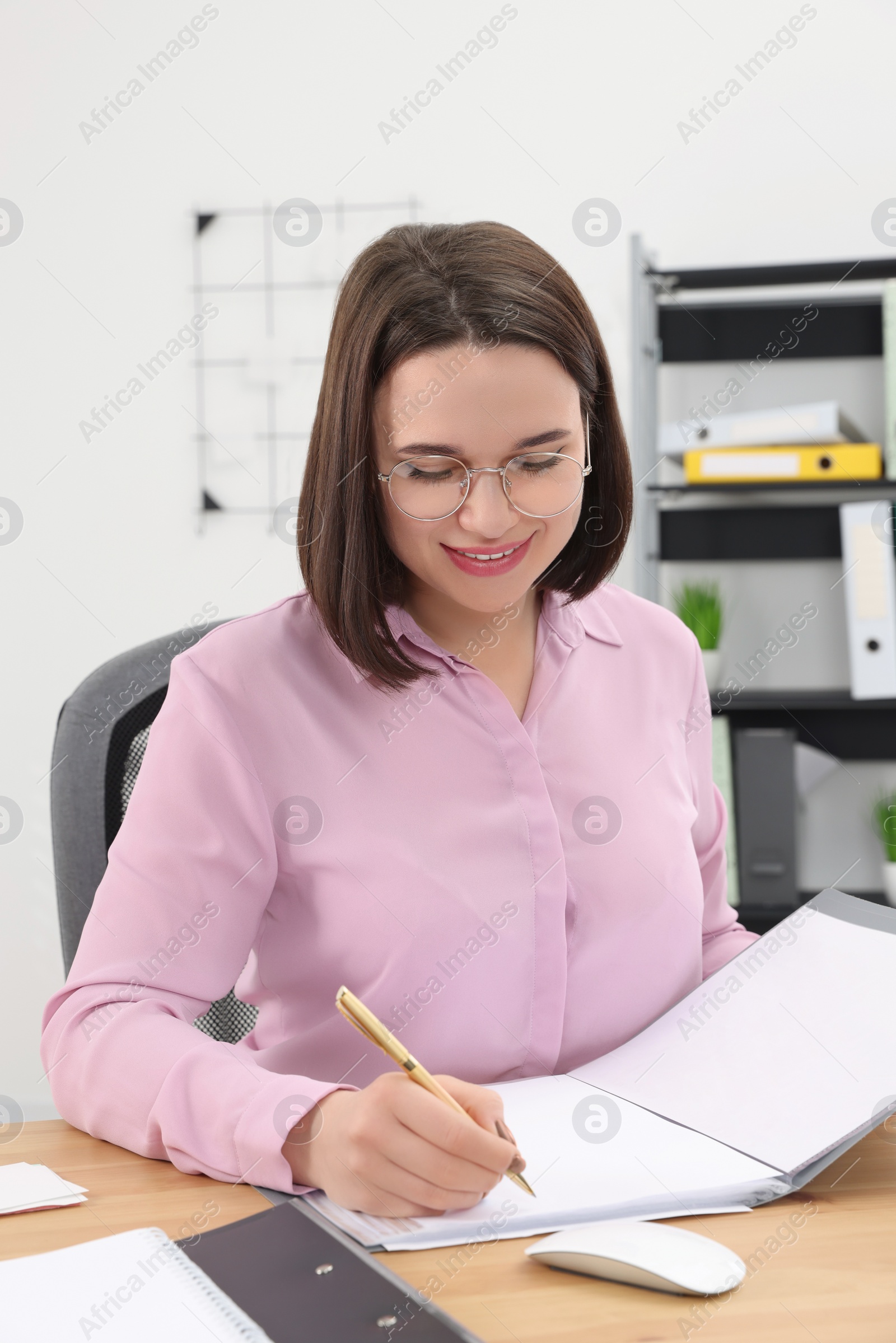 Photo of Happy young intern working at table in modern office