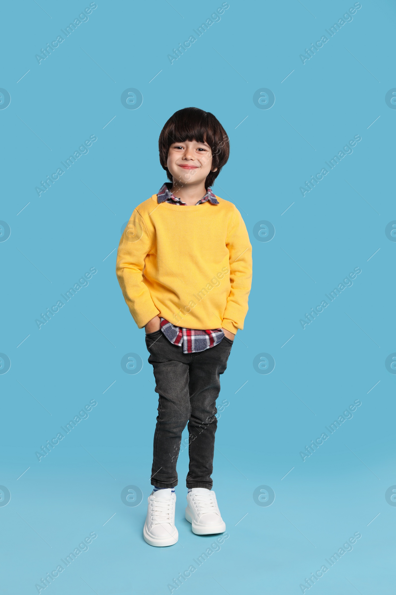 Photo of Full length portrait of cute little boy on light blue background