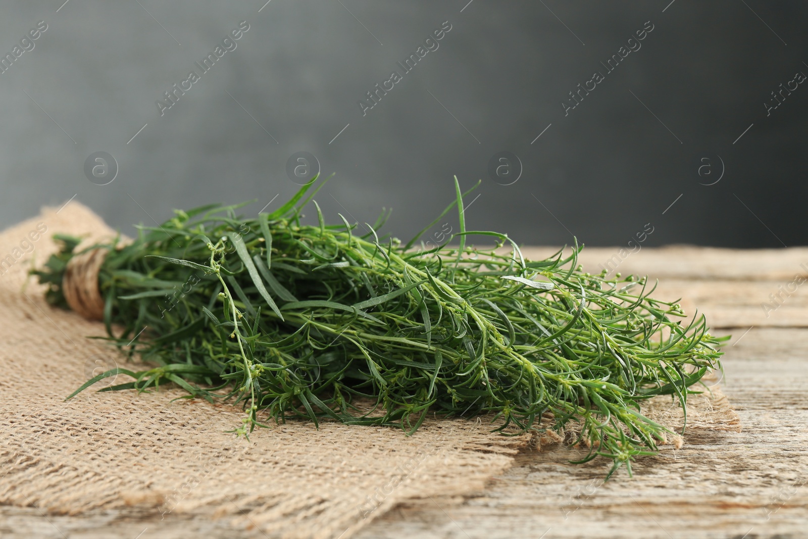 Photo of Bunch of fresh tarragon sprigs on wooden table