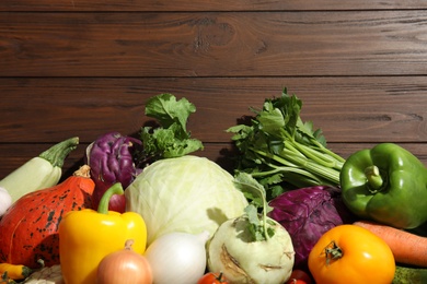 Photo of Many fresh ripe vegetables on wooden background, top view. Organic food