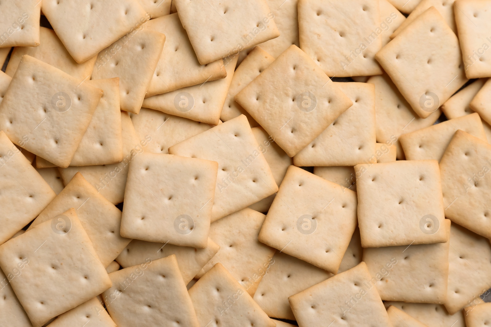 Photo of Many delicious crackers as background, top view