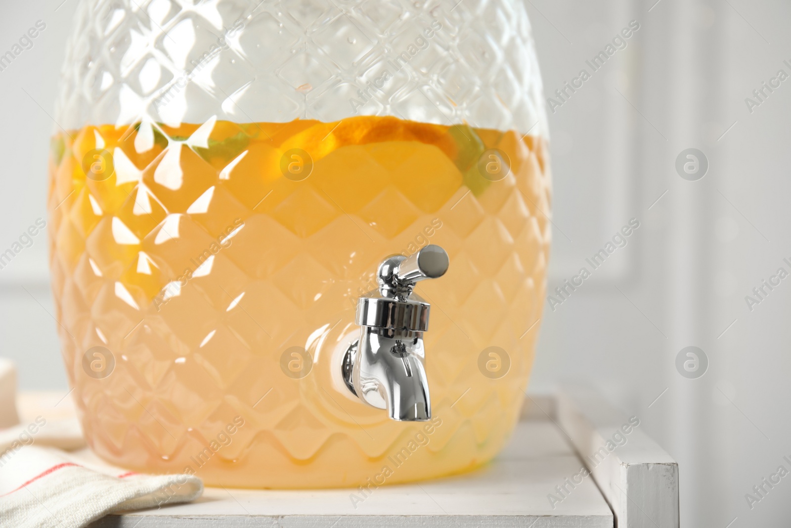Photo of Beverage dispenser with delicious refreshing drink on white wooden table, closeup
