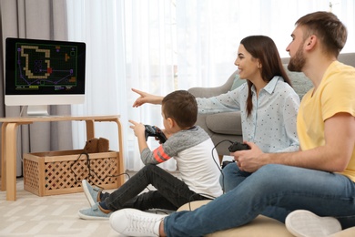 Happy family playing video games at home. Space for text