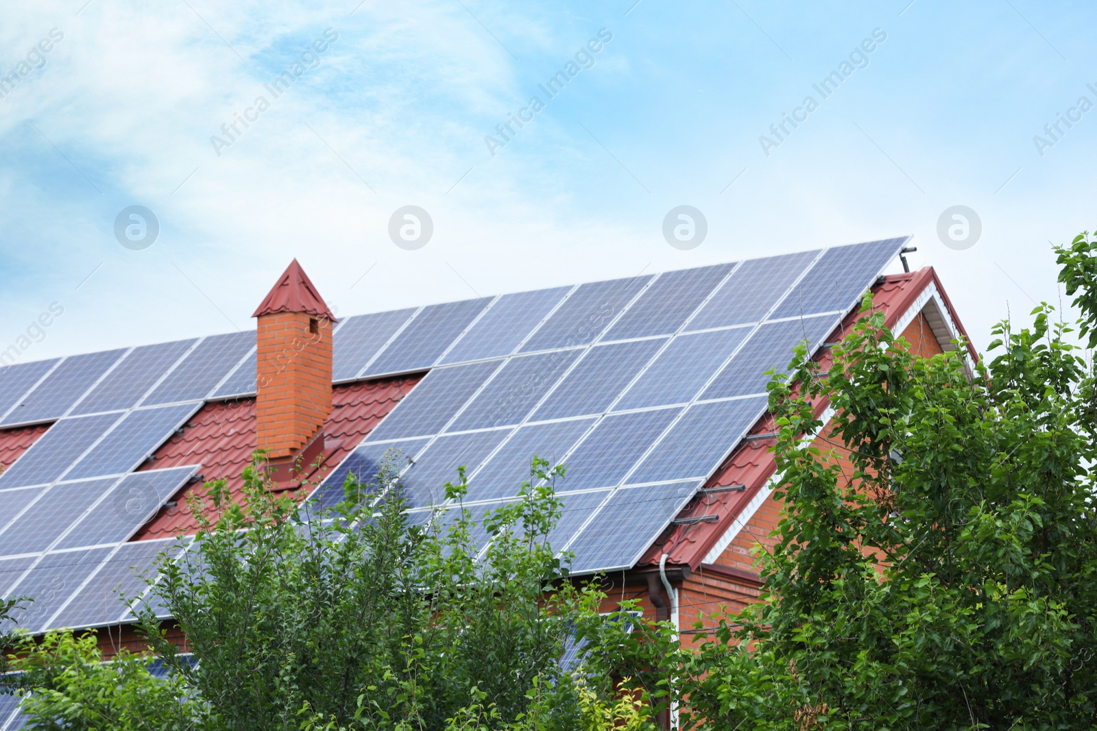 Photo of House with installed solar panels on roof. Alternative energy source