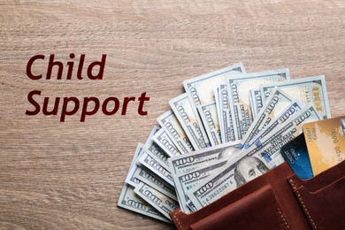 Image of Child support concept. Many dollar banknotes with wallet and credit cards on wooden table, flat lay