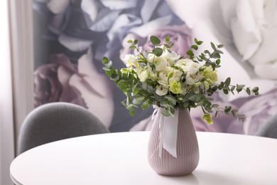 Photo of Vase with beautiful bouquet on white table indoors. Stylish interior element