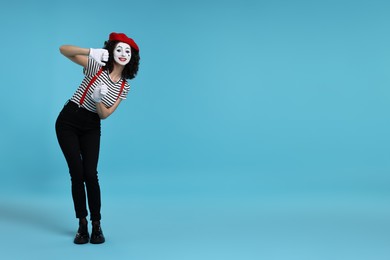 Photo of Funny mime with beret posing on light blue background, space for text